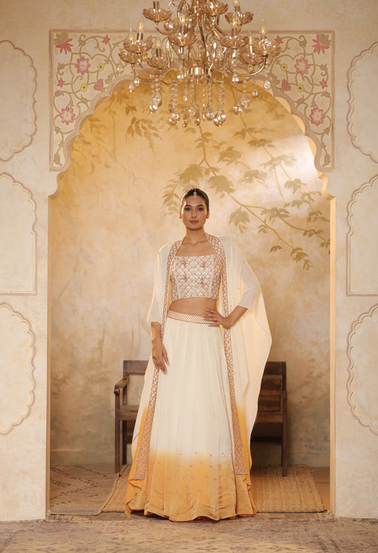 Woman in a traditional outfit standing in an ornate doorway with a chandelier above.