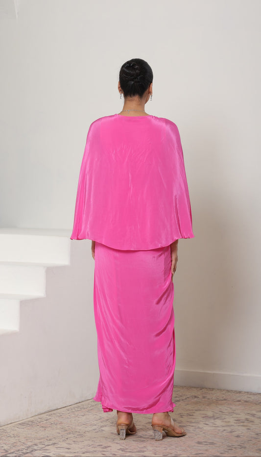 Person wearing a bright pink outfit standing on a staircase with a white wall background; Pink crepe kaftan, V-neck designer kaftan, elegant cocktail outfit, premium evening wear, stylish festive kaftan, Sunanta Madaan