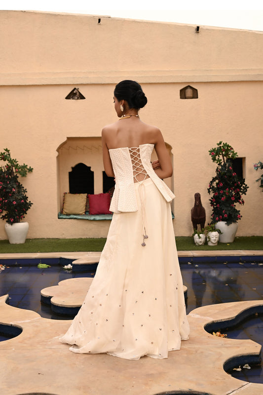 Elegant bridal lehenga featuring a beautiful corset-style crop top. This designer bridal lehenga from Sunantamadaan is perfect for weddings, showcasing trending white lehenga designs. A stunning off-white lehenga ideal for brides, available for lehenga shopping online at a trusted lehenga store. Shop now for the latest collection of lehengas for weddings and find your dream bridal outfit.