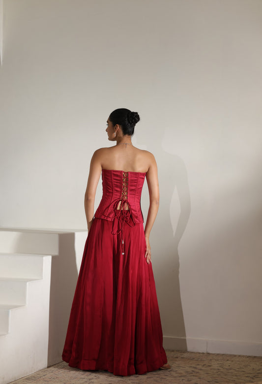 Woman wearing a red strapless gown with lace details against a plain background; Sunanta Madaan – Maroon Satin Organza Embroidered Sharara Set, Premium Wedding Wear, Elegant Festive Outfit, Boho Indo-Western Dress, Indo-Western Fusion Wear, Indo-Western Attire for Engagement, Indo-Western Outfit for Sangeet, Indo-Western Draped & Embroidered Skirt, Women’s Designer Party Ensemble, Delhi, Jaipur, Hyderabad, Ahmedabad, Bangalore, near me