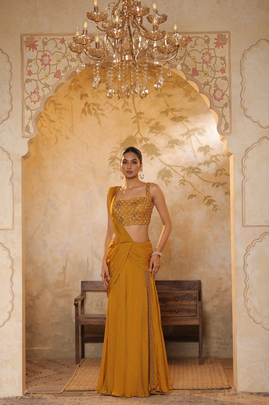 Woman in a mustard yellow saree by Sunanta Madaan standing in an ornate room with a chandelier. Saree by Sunanta Madaan