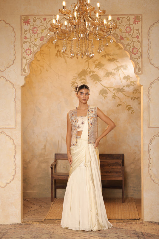 Woman in traditional outfit standing in an ornate room with a chandelier.