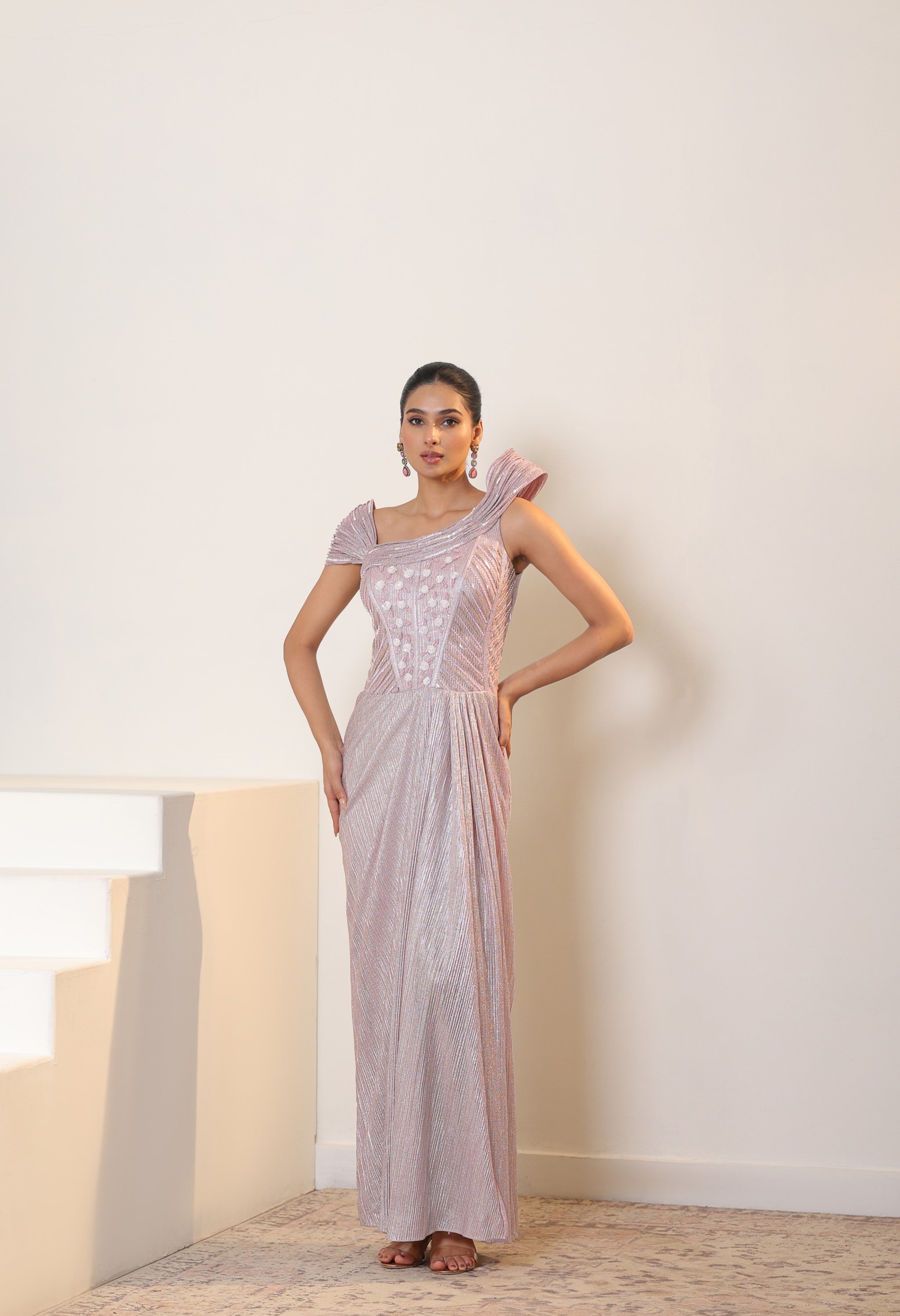 luxurious embroidered saree gown displayed in warm light on a mannequin in studio