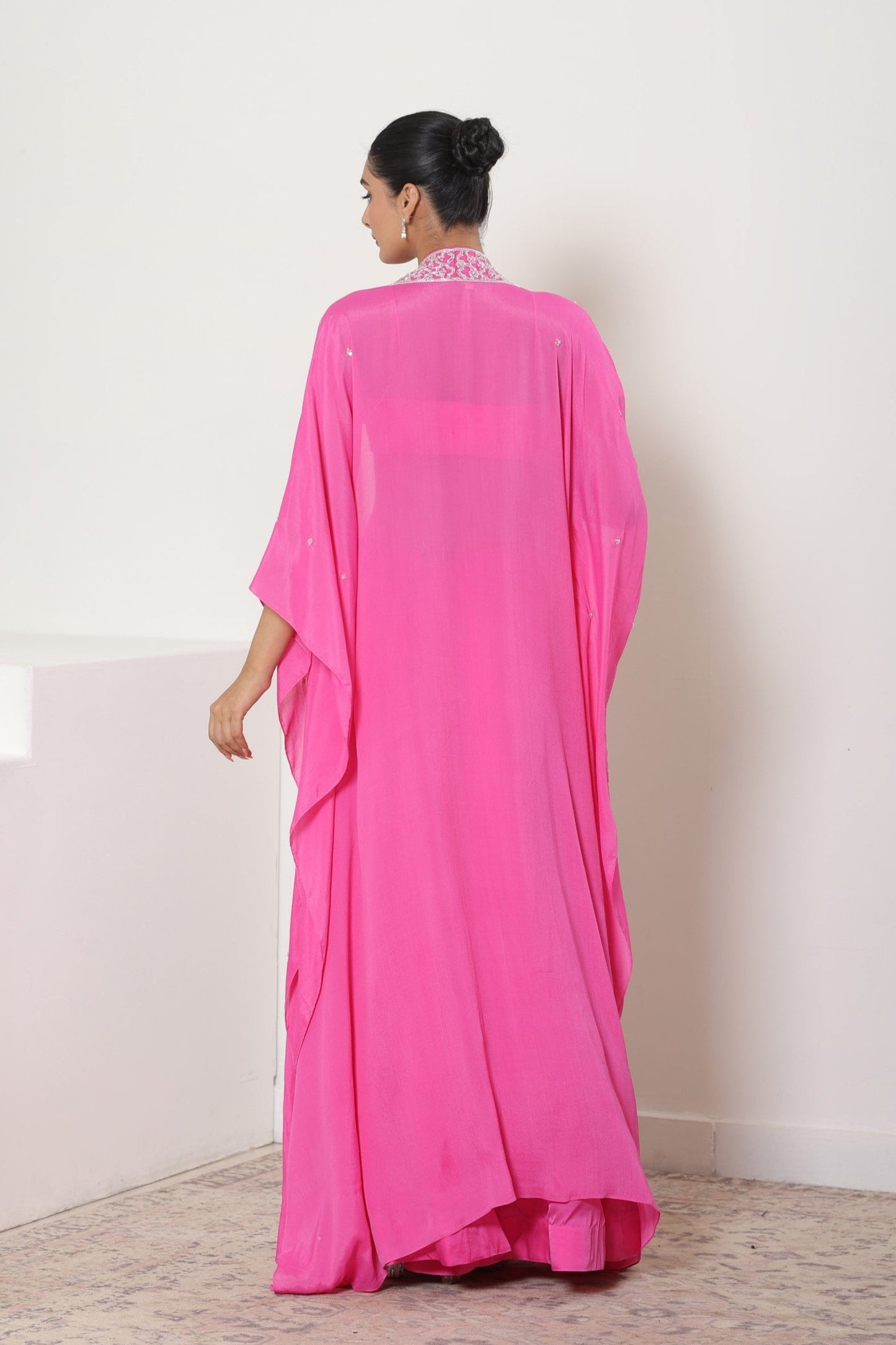 Woman wearing a bright pink dress with a plain white background; Hot pink sharara set, embroidered crepe outfit, handcrafted evening wear, elegant festive attire, designer party ensemble, Sunanta Madaan
