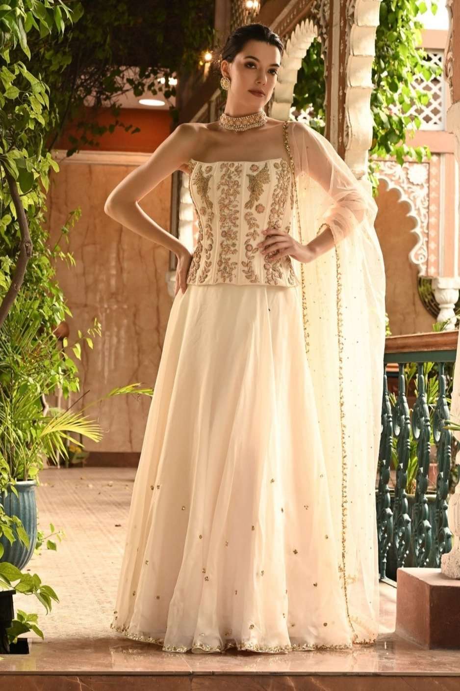 Ivory Indo Western lehenga set featuring a designer lehenga choli with intricate embellishments, perfect for bridal or reception wear. Complete with a matching dupatta, this party wear lehenga is a stunning choice for weddings and special occasions.