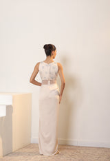 Woman wearing a white dress with lace details in a minimal indoor setting; Sunanta Madaan – Ivory Crepe Satin Western Embroidered Gown, Premium Cocktail Wear, Elegant Party Outfit, Boho Indo-Western Dress, Indo-Western Fusion Wear, Women’s Formal Evening Dress, Indo-Western Outfit for Reception, Party Outfit, Indo-Western Draped Dress, Jaipur, Delhi, Hyderabad, Ahmedabad, Bangalore, near me