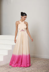 Woman wearing a long, elegant dress with a gradient from beige to pink, standing on a staircase. Ivory pink jumpsuit, satin organza outfit, embroidered festive wear, elegant designer jumpsuit, premium ethnic attire, Sunanta Madaan, near me, Mumbai, Delhi, Hyderabad, Bangalore, Pune