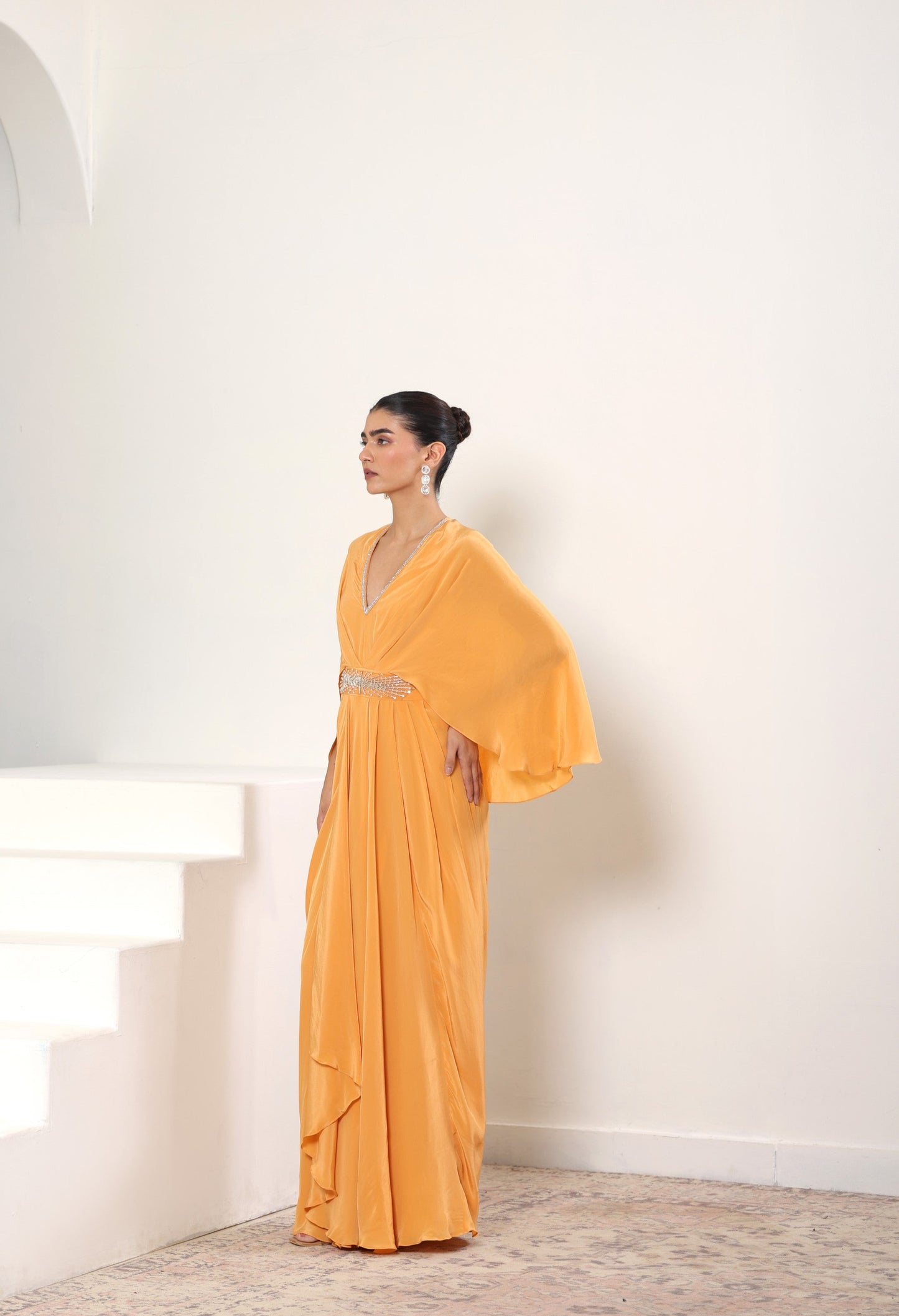 Woman wearing a yellow evening gown with a white background. Orange crepe kaftan, embroidered designer kaftan, luxury evening wear, elegant festive outfit, premium ethnic kaftan, Sunanta Madaan