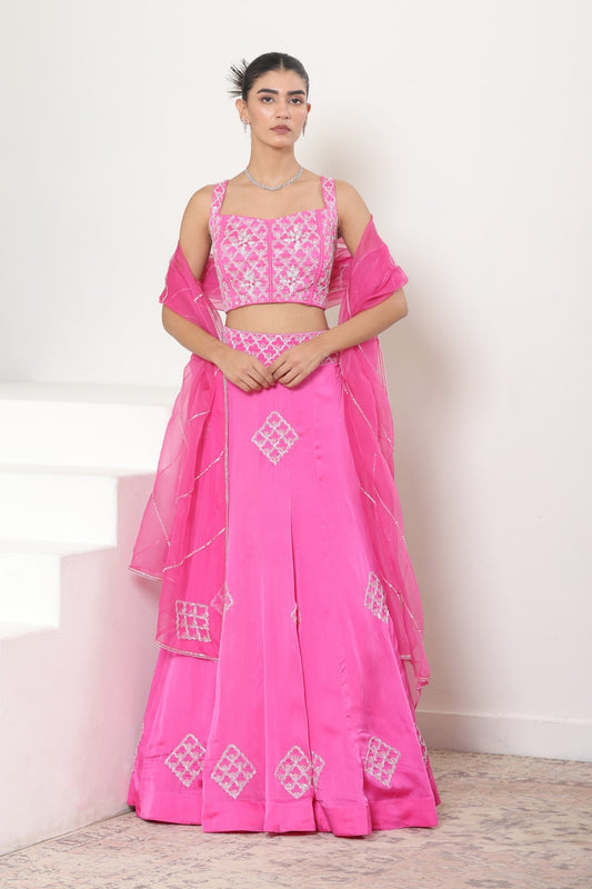 Woman wearing a pink traditional outfit with white embroidery on a light background; Pink satin organza lehenga, embroidered designer outfit, premium reception wear, elegant festive attire, traditional bridal ensemble, Sunanta Madaan, Boho Indo-Western dress, Indo-Western fusion wear, Indo-Western attire for engagement, Indo-Western outfit for sangeet, Indo-Western draped dress, Indo-Western embroidered skirt, Indo-Western embroidered dress, near me, Mumbai, Delhi, Hyderabad, Bangalore, Pune