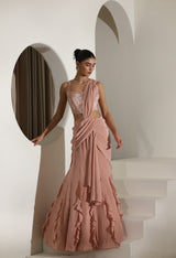 Woman in a pink gown standing in a white architectural setting; Sunanta Madaan – Mocha Mousse Crepe Embroidered Drape Lehenga Saree, Premium Festive Wear, Elegant Party Outfit, Boho Indo-Western Dress, Indo-Western Fusion Wear, Indo-Western Attire for Engagement, Indo-Western Outfit for Sangeet, Indo-Western Draped & Embroidered Skirt, Women’s Designer Festive Ensemble, Delhi, Jaipur, Hyderabad, Ahmedabad, Bangalore, near me