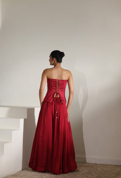 Woman wearing a red strapless gown with lace details against a plain background; Sunanta Madaan – Maroon Satin Organza Embroidered Sharara Set, Premium Wedding Wear, Elegant Festive Outfit, Boho Indo-Western Dress, Indo-Western Fusion Wear, Indo-Western Attire for Engagement, Indo-Western Outfit for Sangeet, Indo-Western Draped & Embroidered Skirt, Women’s Designer Party Ensemble, Delhi, Jaipur, Hyderabad, Ahmedabad, Bangalore, near me