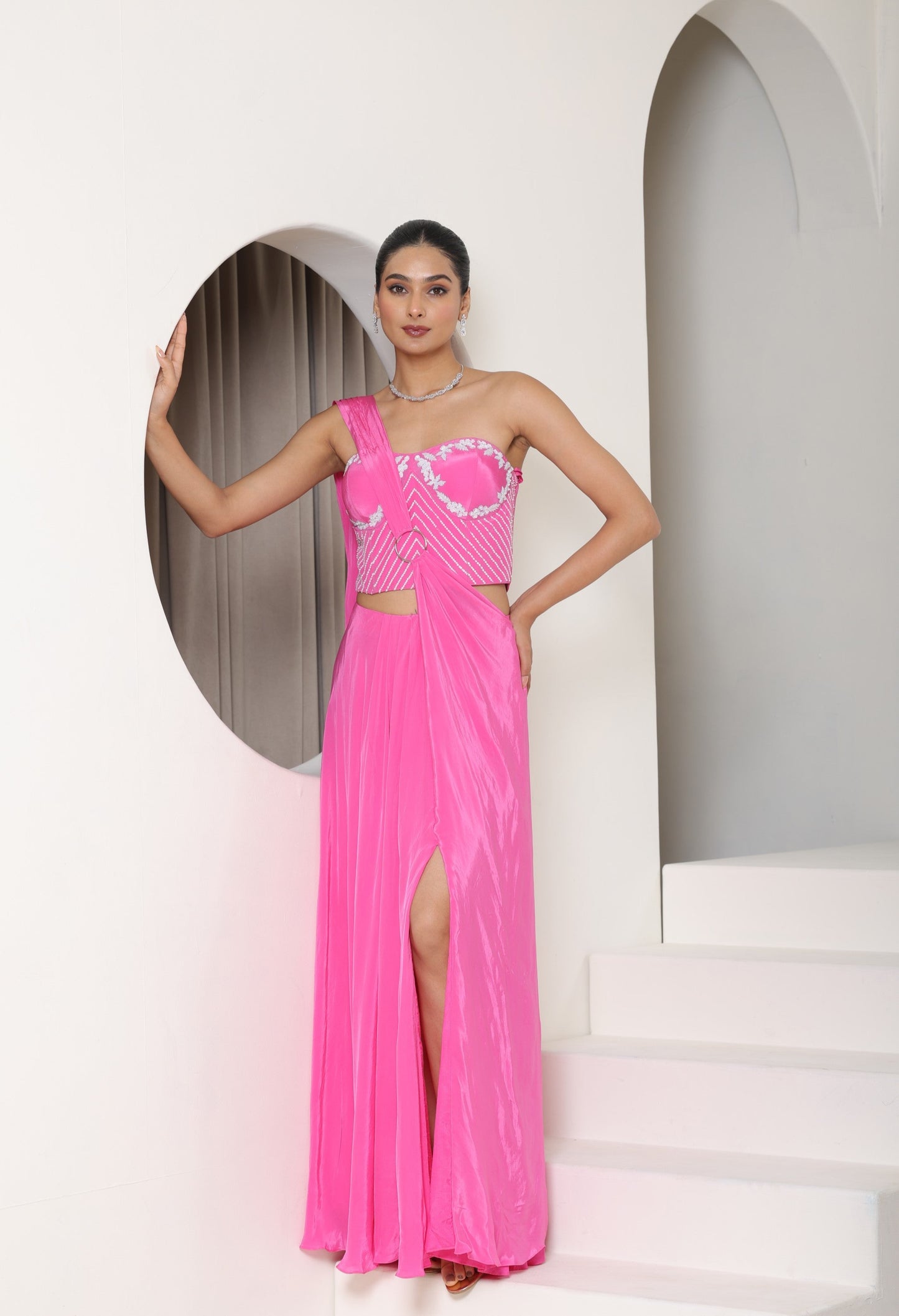 Woman wearing a pink evening gown with a white background; Hot pink crepe saree, hand embroidered saree, premium cocktail outfit, elegant evening wear, designer festive saree, Sunanta Madaan