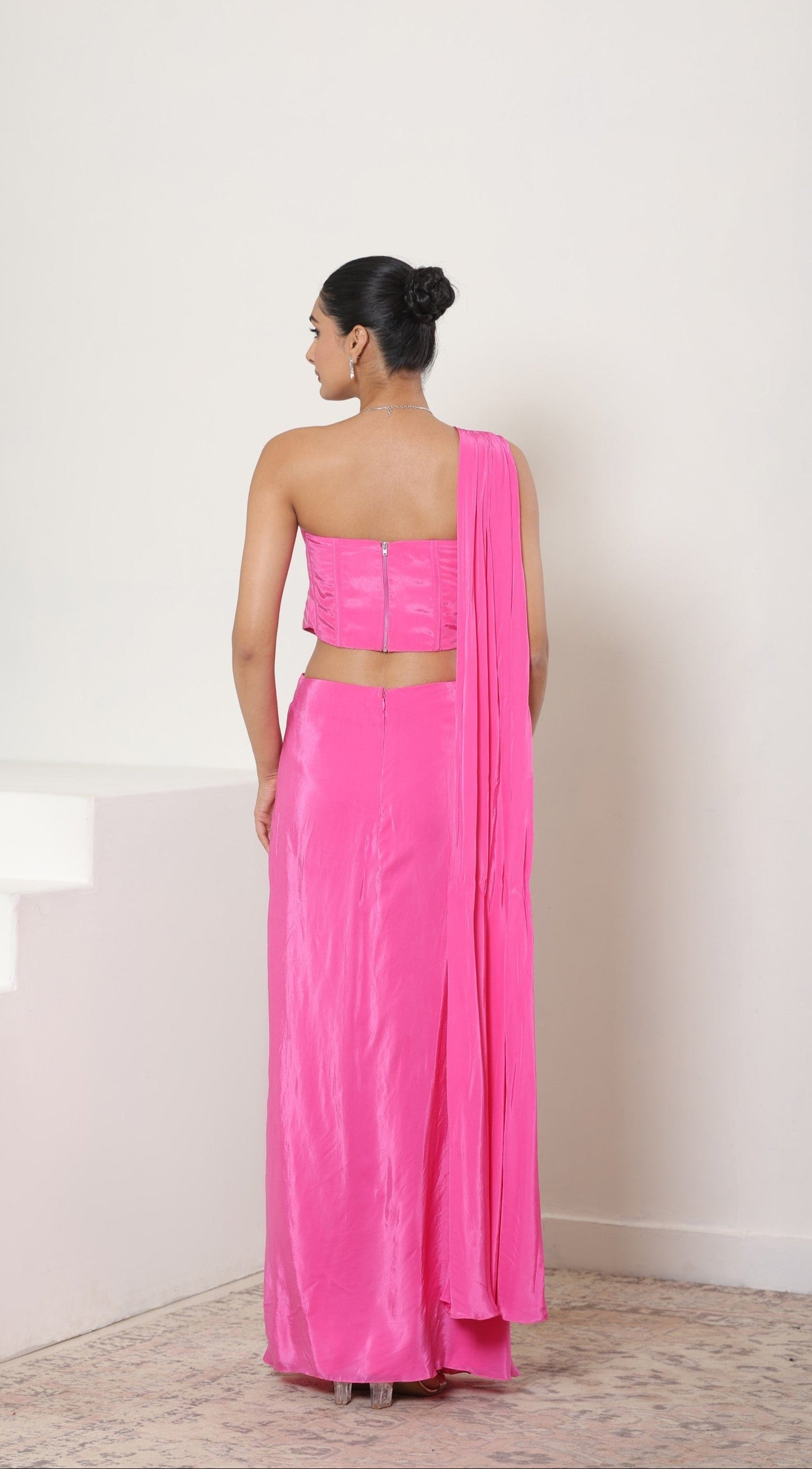 Woman wearing a bright pink saree with a matching blouse on a white background; Hot pink crepe saree, hand embroidered saree, premium cocktail outfit, elegant evening wear, designer festive saree, Sunanta Madaan