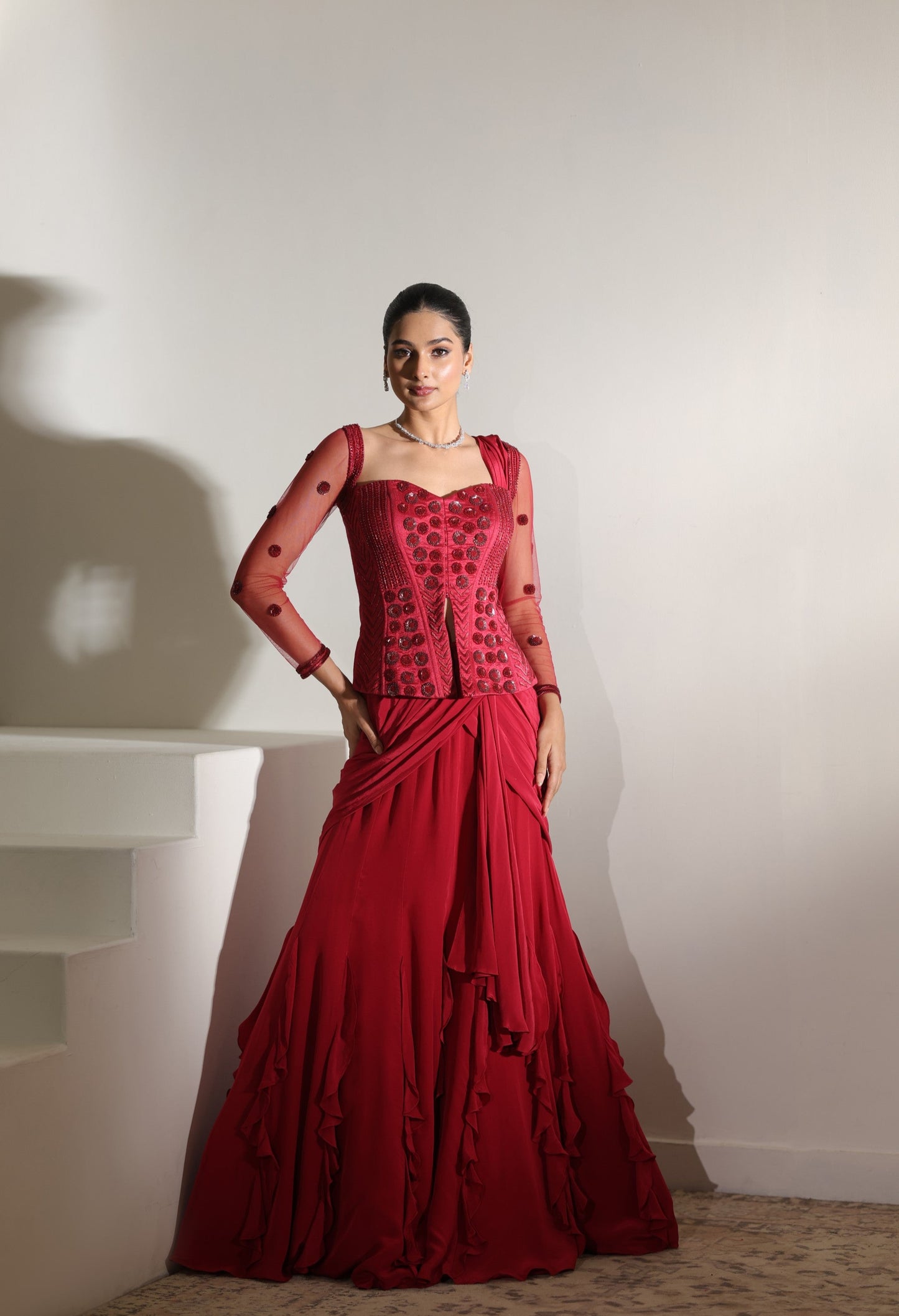 Woman wearing a red dress with a white background; Sunanta Madaan – Burgundy Raw Silk & Crepe Embroidered Corset Saree, Premium Designer Wear, Elegant Festive Outfit, Boho Indo-Western Dress, Indo-Western Fusion Wear, Indo-Western Attire for Engagement, Indo-Western Outfit for Sangeet, Indo-Western Draped & Embroidered Saree, Women’s Designer Saree, Mumbai, Delhi, Hyderabad, Bangalore, Pune, near me