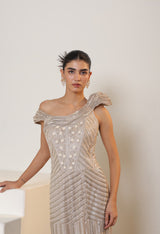 Woman wearing a sparkling silver dress against a plain background; Sunanta Madaan – Champagne Metallic Lycra Crepe Embroidered Gown, Elegant Cocktail Wear, Evening Party Dress, Boho Indo-Western Dress, Indo-Western Fusion Wear, Women’s Formal Gown, Indo-Western Outfit for Reception, Party Outfit, Indo-Western Draped Dress, Jaipur, Delhi, Pune, Ahmedabad, Hyderabad, near me