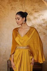 Woman wearing a mustard yellow dress with a textured background. Yellow crepe kaftan, V-neck embroidered kaftan, handcrafted festive outfit, elegant ethnic wear, designer party kaftan, Sunanta Madaan
