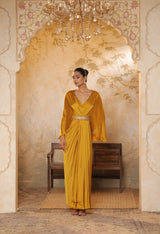 Woman in a yellow saree standing in an ornate room with a chandelier. Yellow crepe kaftan, V-neck embroidered kaftan, handcrafted festive outfit, elegant ethnic wear, designer party kaftan, Sunanta Madaan