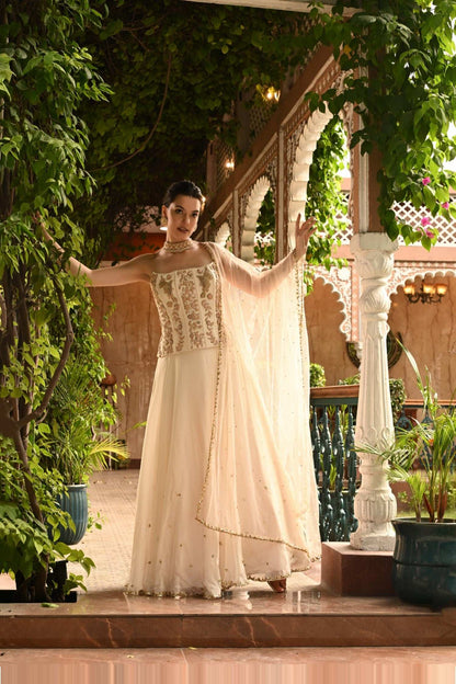 Ivory Indo Western lehenga set with an embroidered coreset, featuring a lehenga with dupatta. This contemporary ethnic lehenga is perfect for traditional or destination weddings, sangeet, or mehendi ceremonies, with minimal embroidery for an elegant look from the wedding collection. Sunanta Madaan